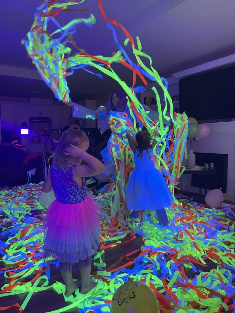 Children playing with glowing ribbons at a Neon Disco party