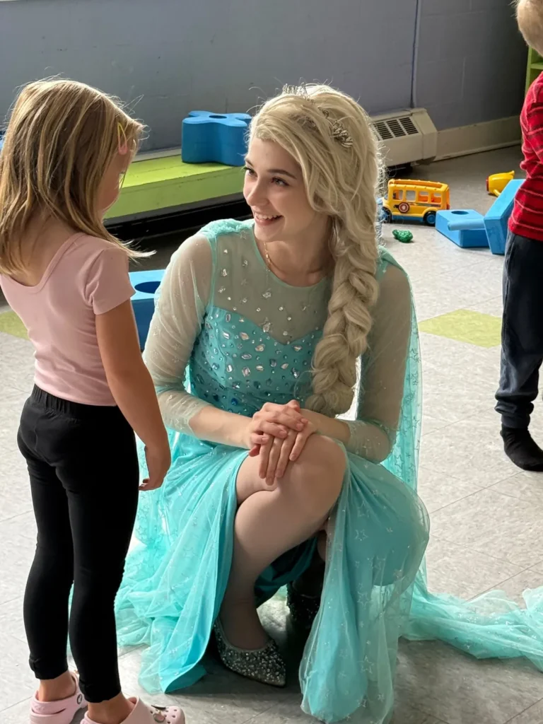 Princess character entertainer talking with a child at a kids party